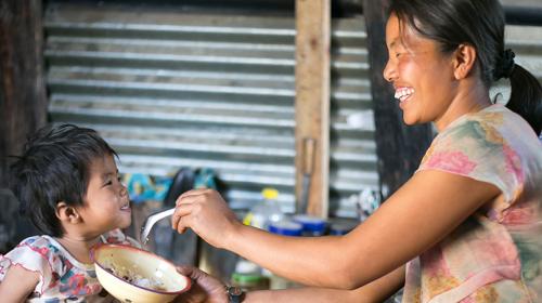 A mother is feeding her two years old daughter (photo taken in Chin State by Jennifer Hardy/CRS)
